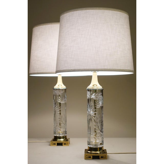 A brilliant and striking pair of slender Hollywood Regency column styled thick deep cut crystal glass & polished Brass...