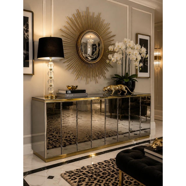 An iconic 1970s Hollywood Regency credenza by Ello, featuring smoked beveled mirror panels framed with polished brass...