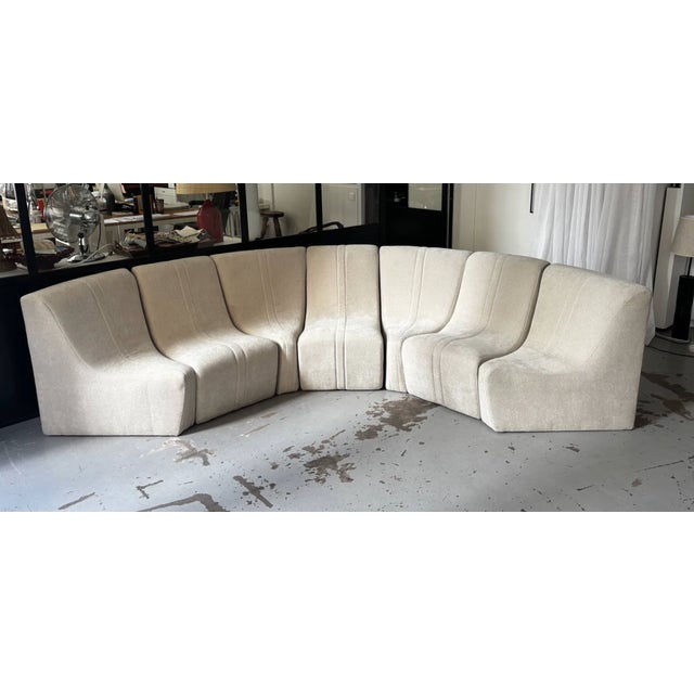 Modular beige sofa composed of 7 elements: 3 straight elements and 4 triangular elements. The elements have been...