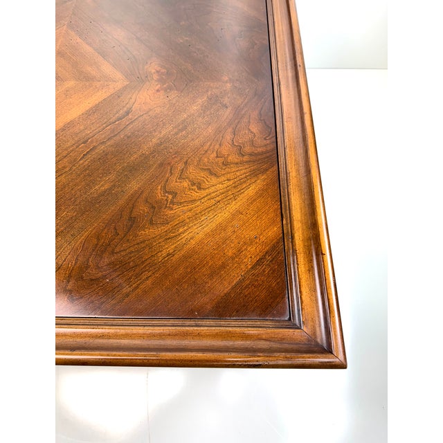 A finely crafted 1960s Lane coffee table featuring a walnut veneer top with a richly figured burl medallion, framed by a...