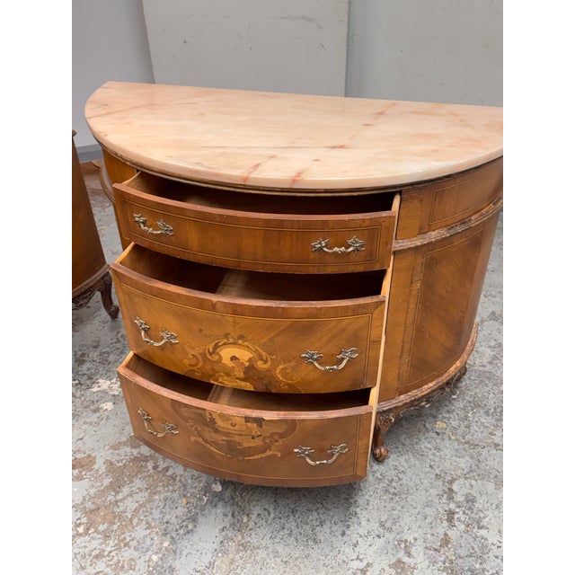 Design Plus Gallery presents a Pair of Neoclassical Semicircular Demi-Lune Commodes. The commode has a shaped marble top...