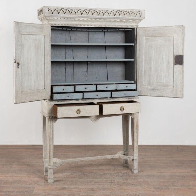 19th century Danish cabinet crafted in oak and raised on tapered fluted legs with a curved stretcher base. Decorative...