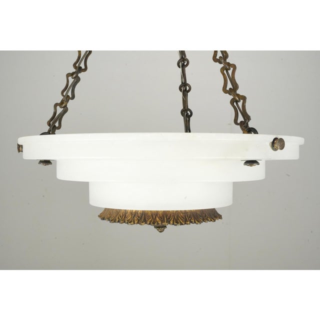 French Art Deco dish pendant light made of natural white alabaster with solid brass accents, rosettes, chain, and finial...
