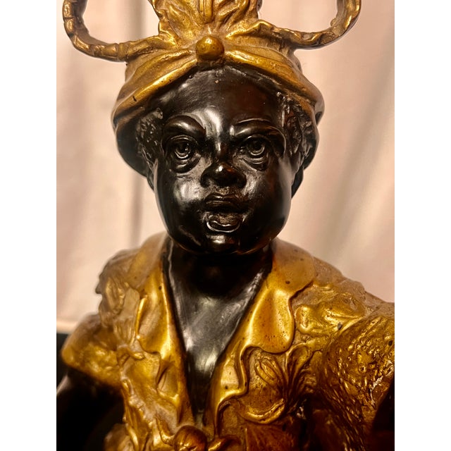 Mid to late 20th century high quality lamp features a child in stylized Eastern attire holding a staff resting on a black...