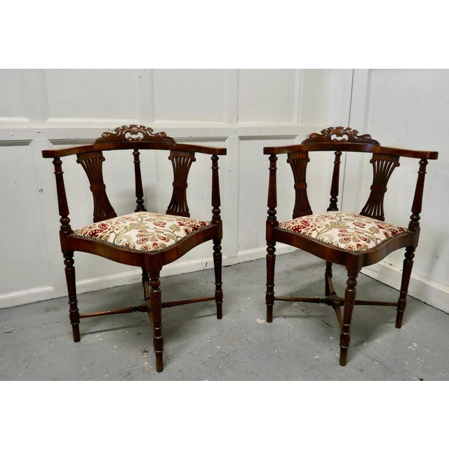 A pair of Edwardian walnut corner arm chairs A beautiful pair of seats, on the back the chairs have gathered fan splats,...