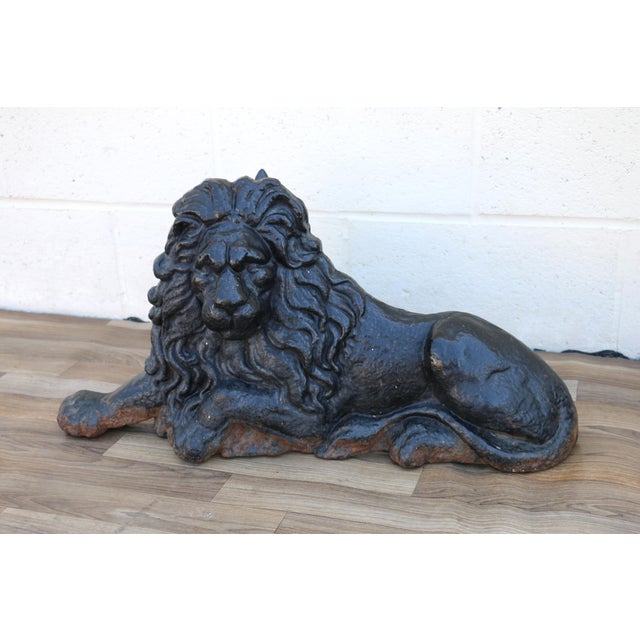 An impressive pair of 19th-century English cast iron lion andirons, featuring beautifully sculpted reclining lions with...