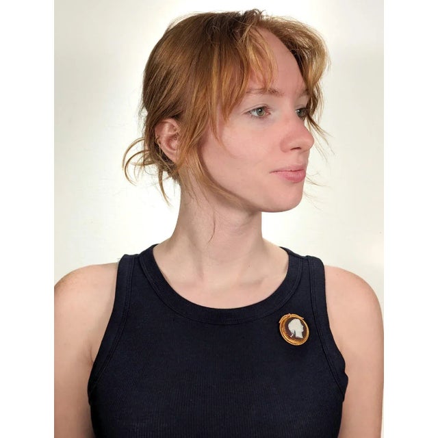 A fine antique cameo brooch. In 18k gold. With a cameo carved agate medallion of a beautiful young woman with headband,...
