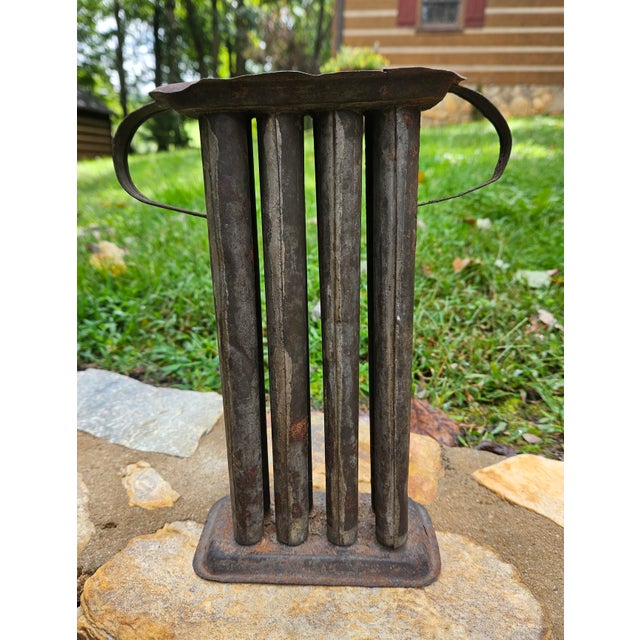 This antique primitive tin candle mold, dating back to the 18th and 19th centuries, was used by threading a cotton wick...