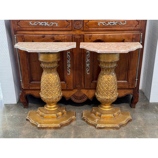 Each of these 20th century French consoles is a single carved pineapple on a stepped, shaped base, gilded all over, with a...