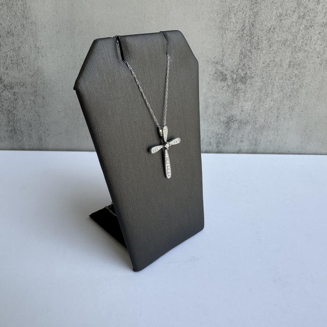 Embrace timeless elegance with this beautiful Diamond Cross Necklace in 14kt White Gold. Adorned with 0.10 carats of...