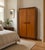A compact 1960s teak wardrobe by White & Newton, with two doors, rectangular wooden handles and darker contrasting trim....