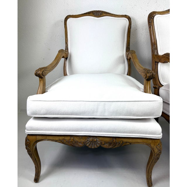 This is a vintage pair of hand carved French country style armchairs. These armchairs have been hand carved with a shell...