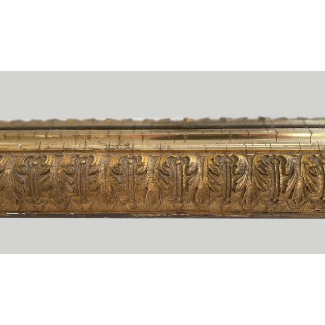 Early 20th century antique rectangular mirror. Crafted from gilded wood, featuring a decorative frieze with palm leaf or...