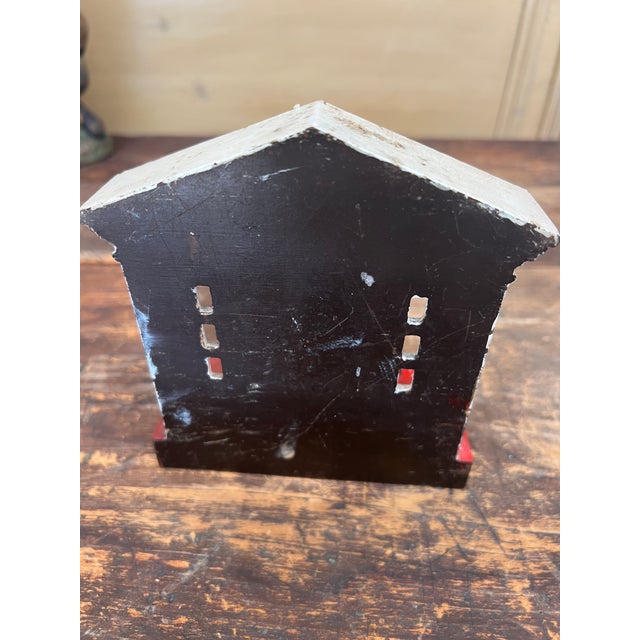 This is an antique doorstop. It depicts the figural front door pillar of a mansion home. It has a detailed entrance with...