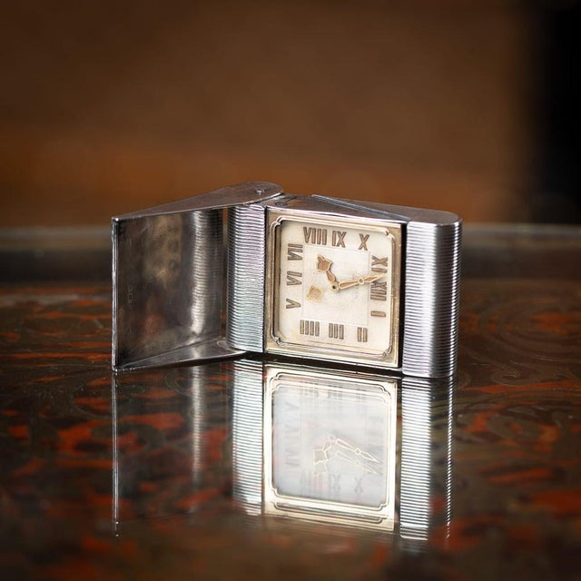 Antique 20th Century French solid silver Cartier travel clock, elegantly crafted with an engine turned outer case. When...