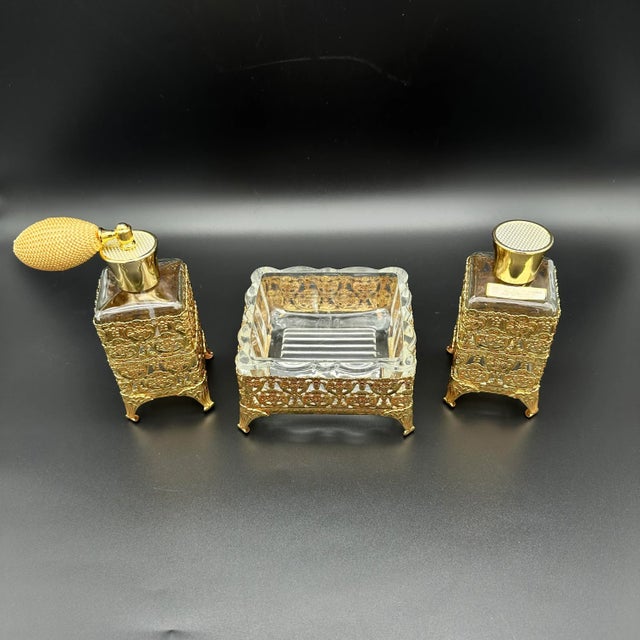 Enhance a vanity with this vintage Ormolu filigree gold gilt set. The set includes three charming pieces, two perfume...