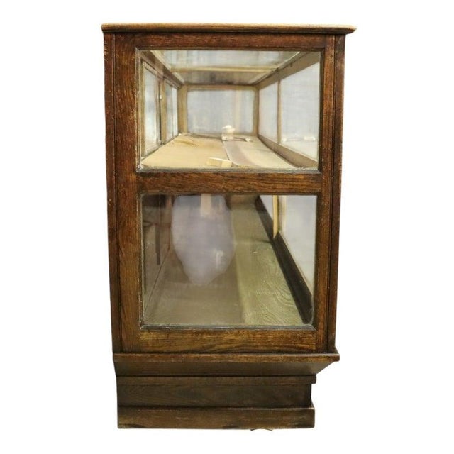 An impressive antique country store display cabinet crafted from oak and glass, dating to approximately 1920. This...