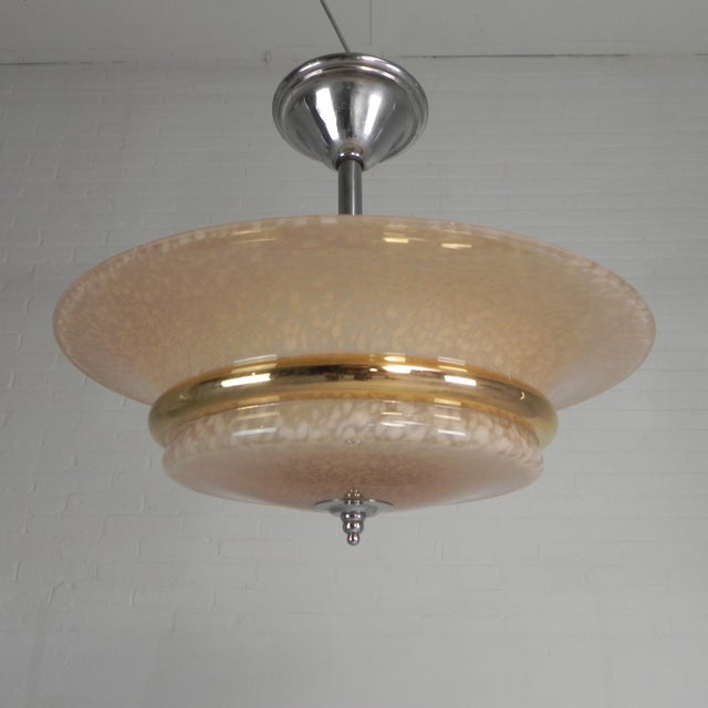 An elegant art deco pendant lamp featuring a beautiful cloudy glass shade, finished with a refined gold band. the cloudy...