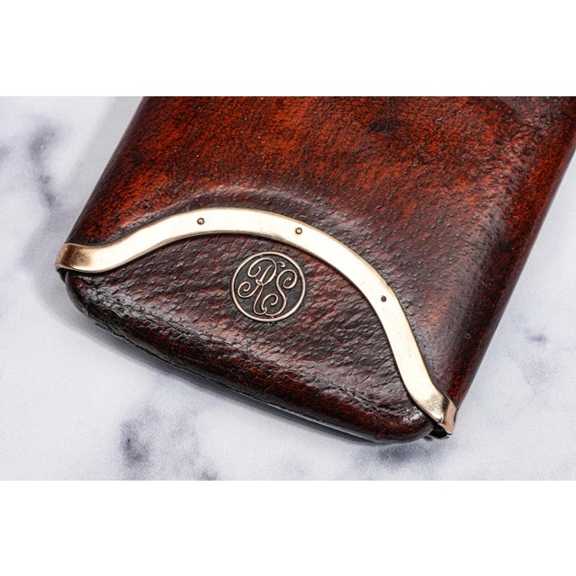 Experience the epitome of vintage luxury with this rare and elegant piece: a 9kt Gold-Rimmed Art Deco Leather Cigar Case...