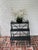 A charming vintage wrought iron conservatory stand featuring three graduated, display shelves, decorative gallery, rails,...