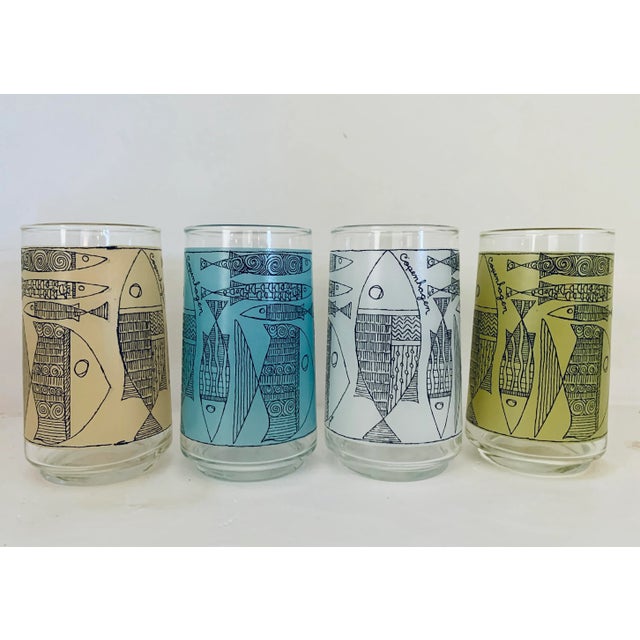 A set of 4 1950s Copenhagen drinking glasses decorated with stylized fishes outlined in black. The background colors of...