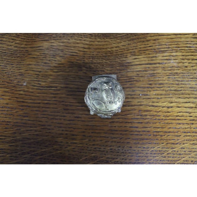 Small antique silver-plated ring or jewelry box with an oval hinged form raised on four decorative feet. The lid is...