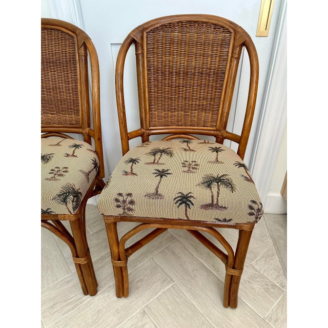 Pair of old Florida style rattan chairs with palm tree print fabric. Made in the Philippines
