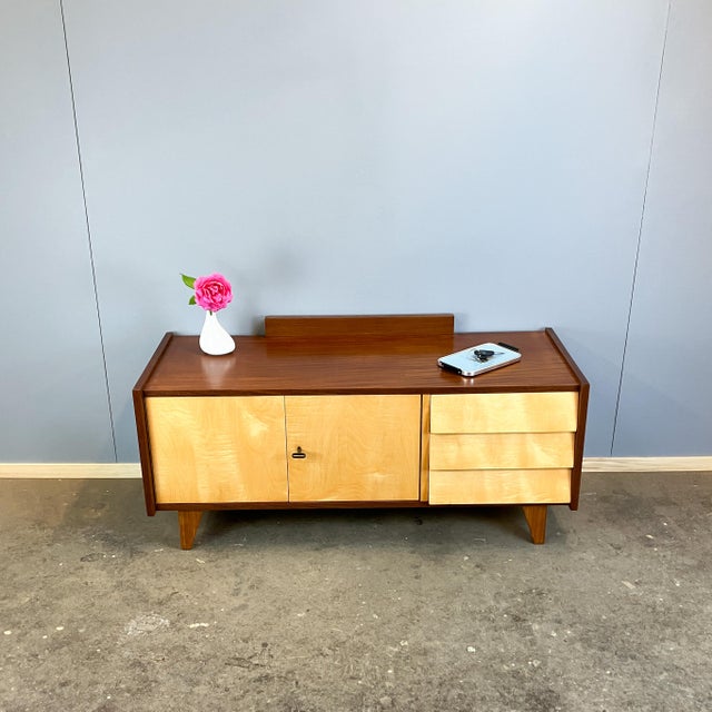 A unique lowboard in a classic 1960s design, featuring a beautiful contrast between the darker body and lighter fronts....