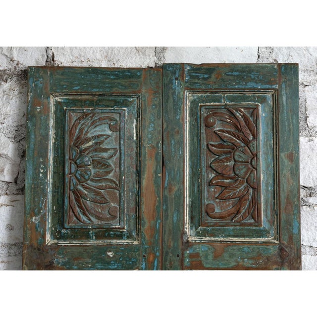 Make a bold artistic statement with this vintage carved sliding barn door, adorned with intricate blue floral detailing...