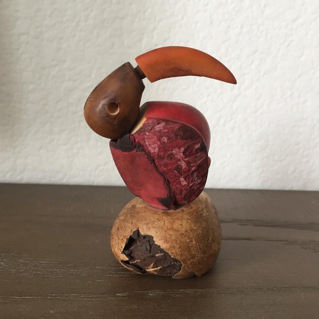 This unique folk art toucan sculpture is hand crafted from tagua nuts with the seed skin left intact, creating a beautiful...