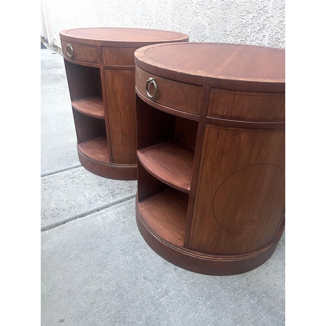 Classic, solid tables by Baker. This pair of side tables are round Barrel Tables with a pull out drawer and side...