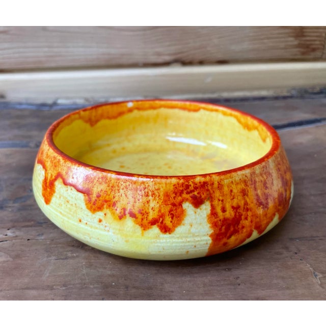 A strikingly beautiful ceramic bowl that looks as if it is dripping in orange flames. The slight crackle in the glaze...