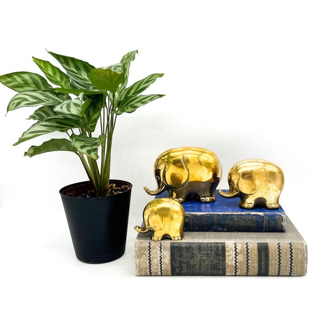 Whimsical set of three solid brass elephant figurines by Jack Housman Inc., retaining the original maker's label on the...