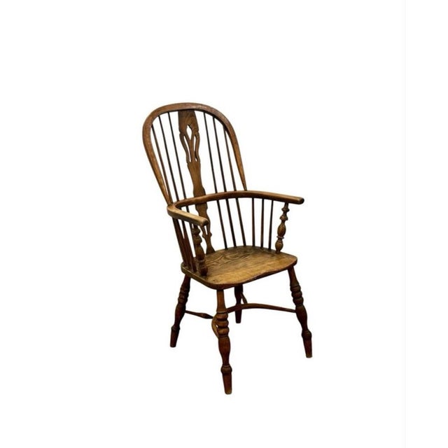 English Windsor chair, circa 1870, made of elm wood. The backrest features thin vertical spindles fitted directly into the...