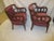 Pair of plum velvet upholstered barrel backed Hollywood Regency circle armchairs. Chairs are dark stained and have...