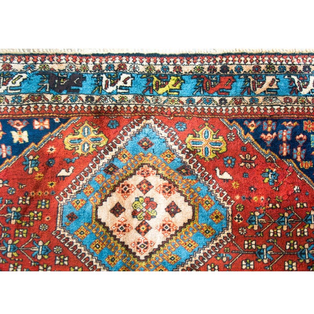 A stunning vintage Persian Yallameh rug with three large central diamond medallions woven with stylized flowers and vines,...