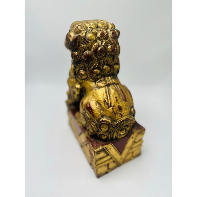This is a decorative guardian lion (foo dog) figurine. Appearance • A small seated lion-like creature with an open mouth...