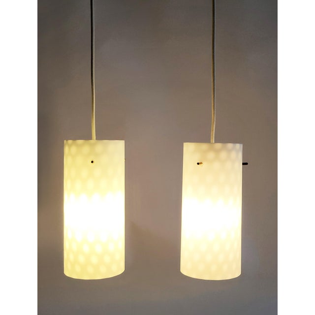Set of 2 elegant, slender white mid-century modern Rupert Nikoll glass pendant lights with brass socket, new ivory white...