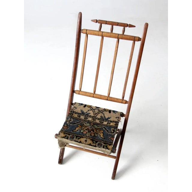 This late 19th century Victorian folding camp chair features a turned wood frame, decorative spindle back with pointed...