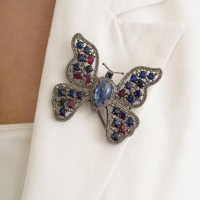 The Boho Chic 10 Ct Tanzanite, Glass-Filled Ruby, Kyanite & Diamond Butterfly Statement Brooch Pendant is crafted in 925...