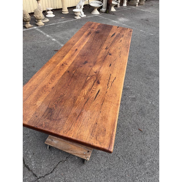 This is a stunning 19th-century French trestle table that features a sturdy base with two supporting legs joined by a...