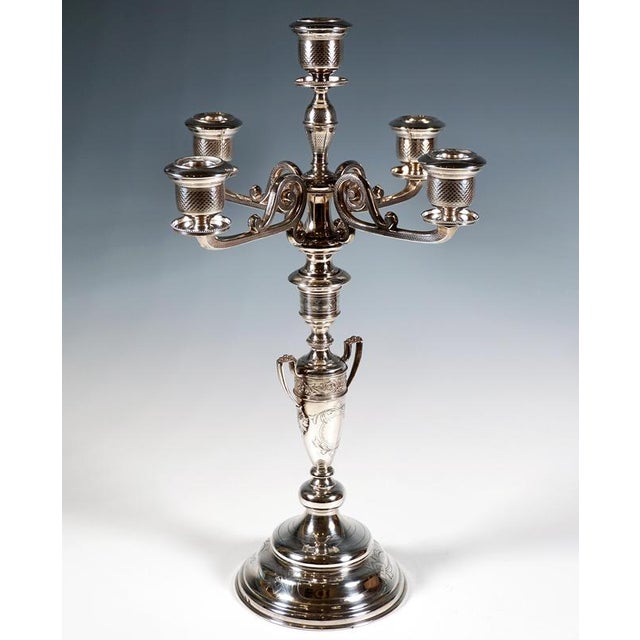 Tall, festive silver candelabrum on a stepped, funnel-shaped base; baluster shaft featuring an inlaid, stylised amphora-...