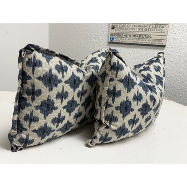 Design Plus Gallery presents a pair of Blue + Ivory Ikat Throw Pillows. Each pillow is upholstered in a woven textile...