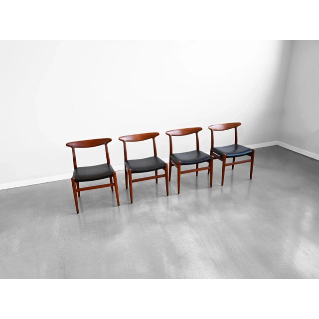 Vintage set of four 'W2' dining chairs crafted in solid teak with black leather upholstery by Hans J. Wegner for C.M....