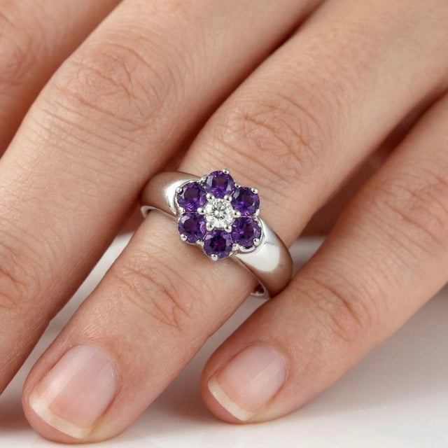 Delicate and timeless, this elegant floral-inspired ring features a captivating arrangement of Amethyst gemstones,...