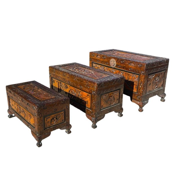Elegant vintage nesting set of three Chinese camphor wood storage chests, crafted in richly grained camphor wood known for...
