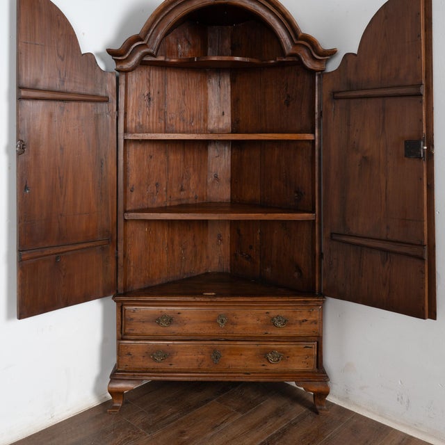 The deep patina of the warm pine in this corner cabinet is a reflection of generations of use, and is crowned by a lovely...