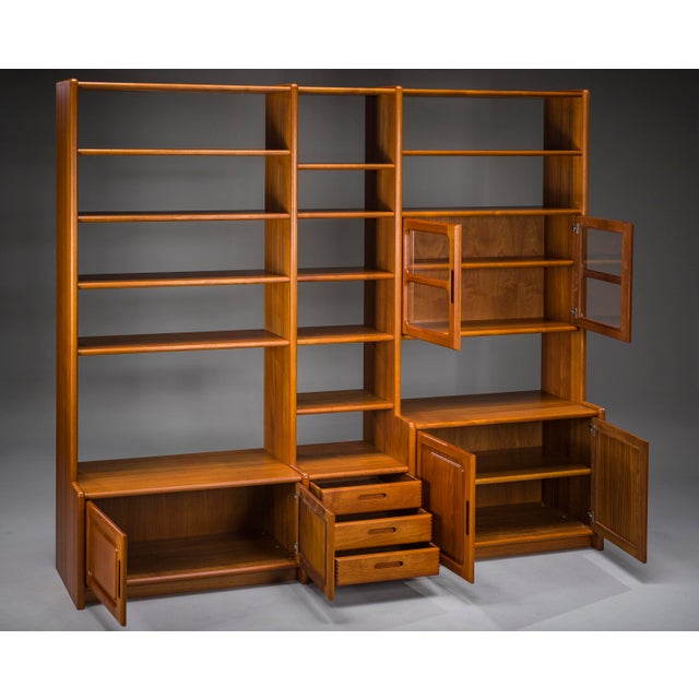 Elegant Danish modular wall unit by Dyrlund, crafted in teak during the 1970s. This versatile Mid-Century Modern storage...