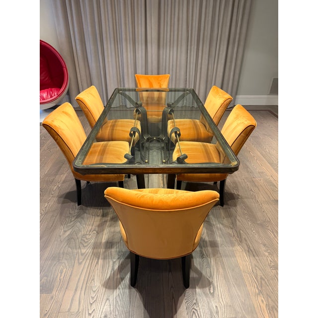 Striking vintage dining table featuring a sculptural wrought iron base paired with a substantial rectangular glass top....