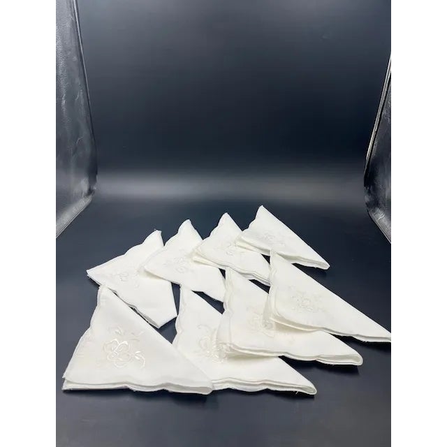 Very pretty set of eight (8) white Dinner Napkins. Each napkin has scalloped edge around with embroidered flower on one...